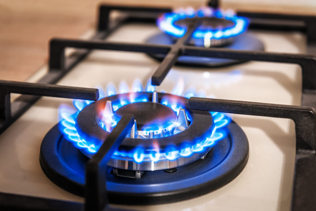 Closeup of blue fire from domestic kitchen stove top