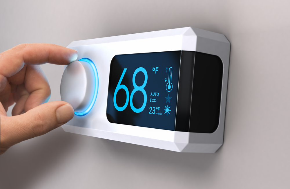 Hand turning a home thermostat