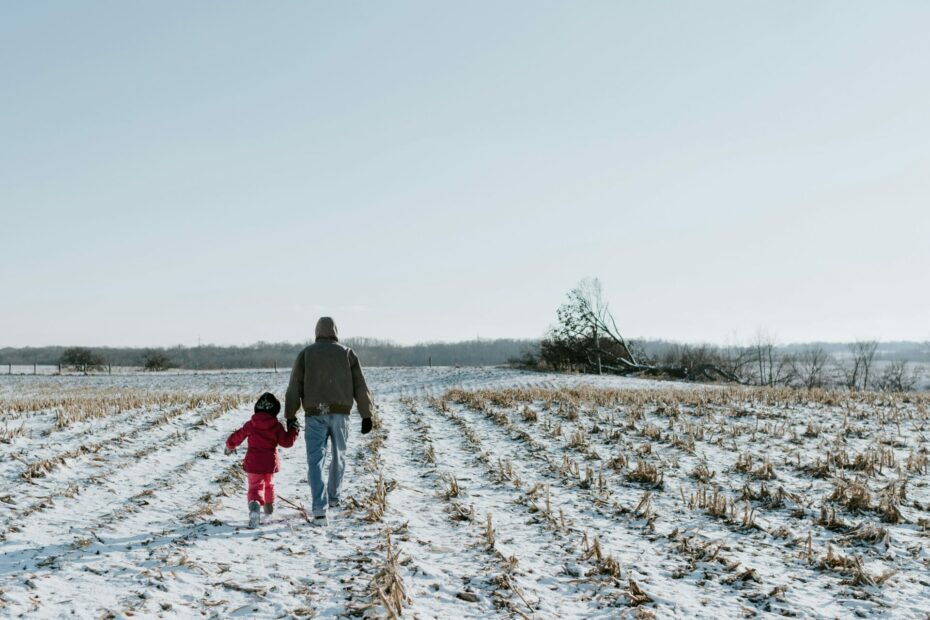 A farm and future generational farmer walking through a snow-covered field they worked on this past harvest.