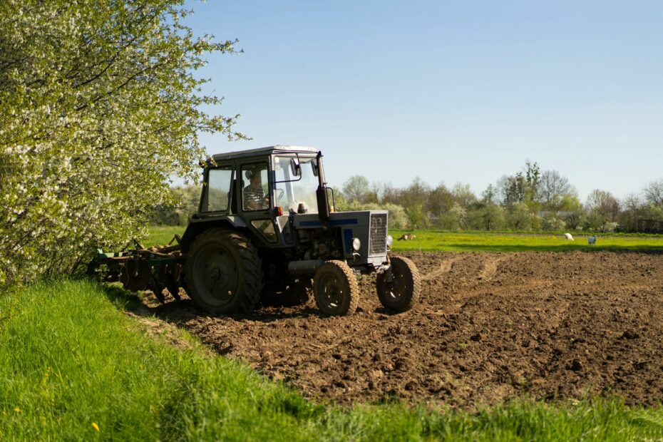 The tractor drives across the field during planting season and cultivates the land.